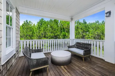a porch with two chairs and a table on it at 172 A Street in Inlet Beach