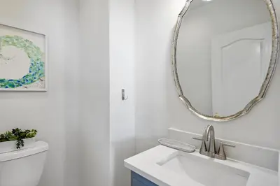a white bathroom with a sink and a mirror at Sandy Boardwalk in Santa Rosa Beach