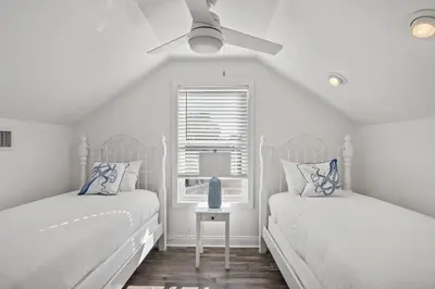 two beds in a white room with a window at Sandy Boardwalk in Santa Rosa Beach