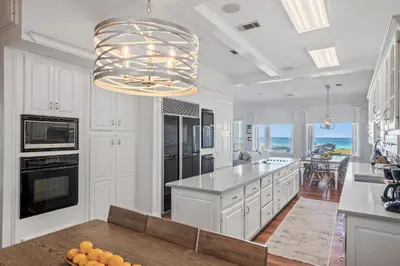 a kitchen with white cabinets and a large island at Sandy Boardwalk in Santa Rosa Beach