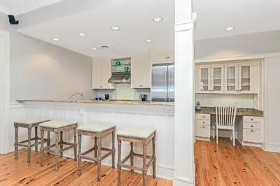 a kitchen with white cabinets and bar stools at Compass Point 1, Unit 204 in Watersound Beach