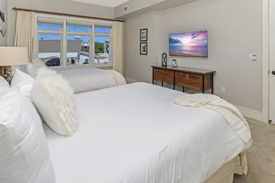 two white beds in a bedroom with a window at Compass Point 1, Unit 204 in Watersound Beach