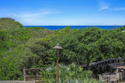 a street light with chairs and trees and the ocean at Compass Point 1, Unit 204 in Watersound Beach