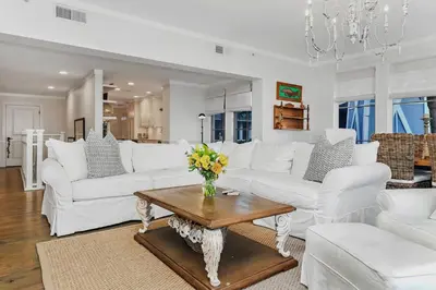 a living room with white furniture and a vase of flowers on a table at Crossings at WaterSound B105 in Watersound Beach