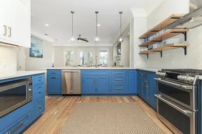 a blue kitchen with white walls and blue cabinets at Paradise Found in Santa Rosa Beach