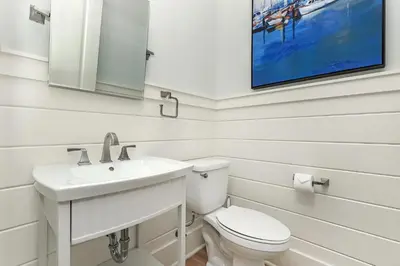 a bathroom with a toilet and a sink and a tv at Paradise Found in Santa Rosa Beach