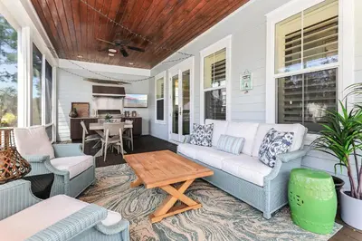 a porch with a couch and chairs and a table at Paradise Found in Santa Rosa Beach