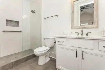 a white bathroom with a toilet and a shower at Paradise Found in Santa Rosa Beach