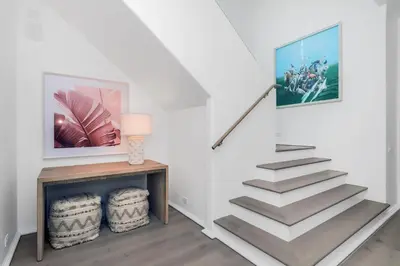 a staircase in a white room with a picture on the wall at Ocean in Inlet Beach