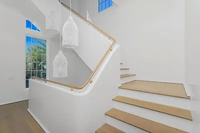 a staircase in a house with white walls and wooden floors at Ocean in Inlet Beach