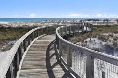 a wooden boardwalk over the beach with the ocean at The Golden Pearl in Watersound Beach