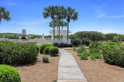 a walkway in a park with palm trees and a monument at The Golden Pearl in Watersound Beach