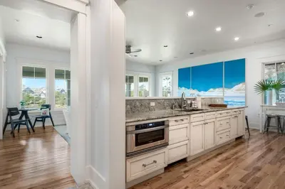 a kitchen with white cabinets and a table with chairs at 217 Gulf Bridge Lane in Watersound Beach