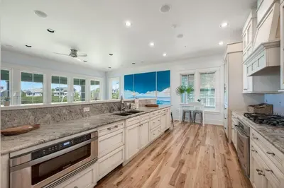 a kitchen with white cabinets and a hardwood floor at 217 Gulf Bridge Lane in Watersound Beach
