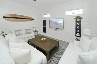 a living room with white couches and a table at Sonshine by the Sea in Santa Rosa Beach