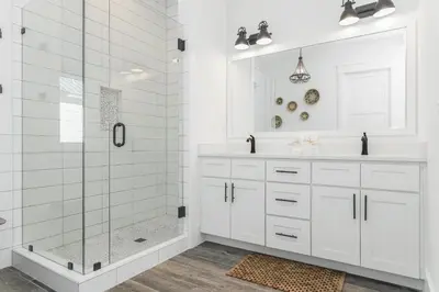a white bathroom with a shower and a sink at Sonshine by the Sea in Santa Rosa Beach