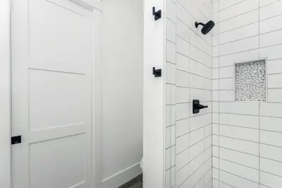a white bathroom with a shower with a white door at Sonshine by the Sea in Santa Rosa Beach