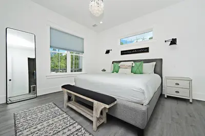 a bedroom with a large bed and a mirror at Sonshine by the Sea in Santa Rosa Beach