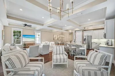 a living room with white furniture and a kitchen at Sea-Rest in Inlet Beach
