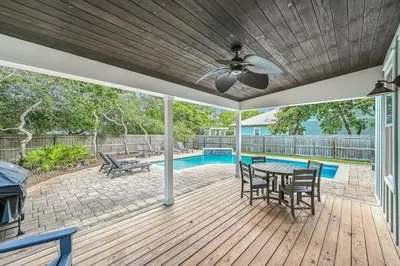 a patio with a table and chairs and a pool at Sea-Rest in Inlet Beach