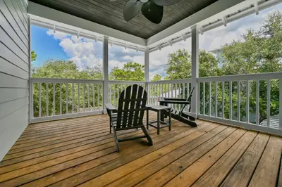 a screened in porch with two chairs and a table at Sea-Rest in Inlet Beach
