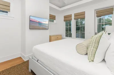 a white bedroom with a large bed and windows at Harp's Haven Main and Carriage in Inlet Beach