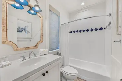 a bathroom with a sink and a toilet and a mirror at 48 Geoff Wilder in Inlet Beach