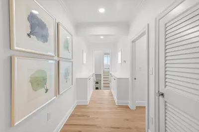 a hallway with white walls and pictures on the walls at Sunsational in Santa Rosa Beach