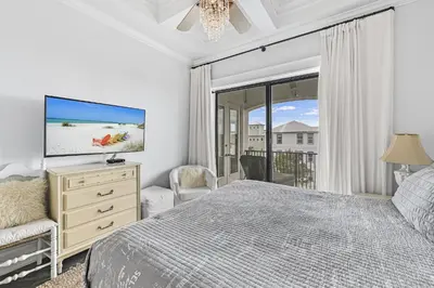 a bedroom with a bed and a tv and a balcony at 15 Mathis Cove in Inlet Beach
