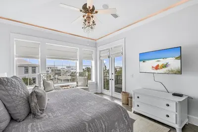 a bedroom with a bed and a flat screen tv at 15 Mathis Cove in Inlet Beach