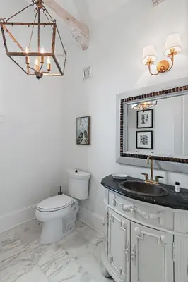 a bathroom with a toilet and a sink and a mirror at 15 Mathis Cove in Inlet Beach