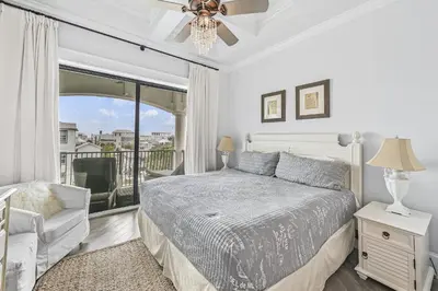 a white bedroom with a bed and a balcony at 15 Mathis Cove in Inlet Beach