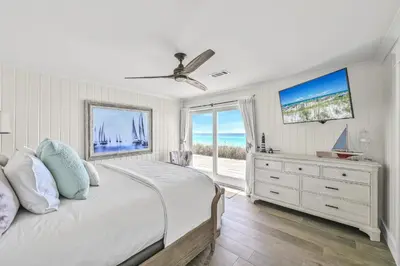 a bedroom with a bed and a dresser with a window at 105 Pelican Circle in Inlet Beach