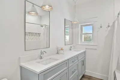 a white bathroom with a sink and a mirror at 105 Pelican Circle in Inlet Beach