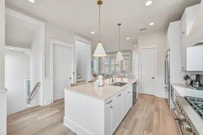 a kitchen with white cabinets and a kitchen island at Sunset Lounge in Santa Rosa Beach
