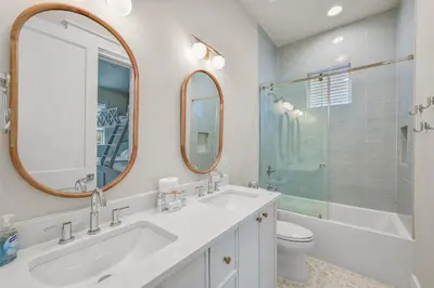 a bathroom with a sink and a toilet and a mirror at Sunset Lounge in Santa Rosa Beach