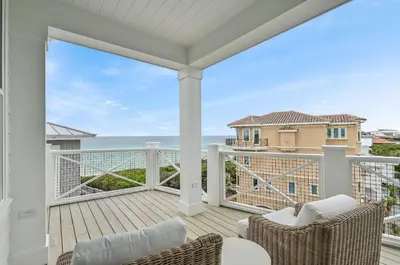 a balcony with chairs and a view of the ocean at Sunset Lounge in Santa Rosa Beach