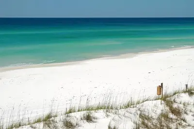 a white beach with the ocean in the background at Sunset Lounge in Santa Rosa Beach