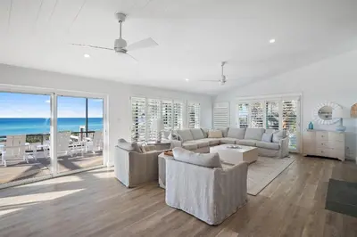 a living room with white furniture and a view of the ocean at 239 Pelican Circle in Inlet Beach