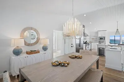 a white kitchen with a table and a dining room at 239 Pelican Circle in Inlet Beach