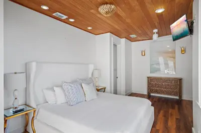 a bedroom with a white bed with a wooden ceiling at 239 Pelican Circle in Inlet Beach