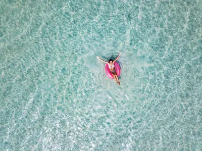 a woman in a pink swimsuit swimming in the water at Bungalow 8 in Watersound Beach