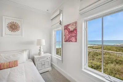 a white bedroom with a bed and a large window at The Flying Pig in Santa Rosa Beach