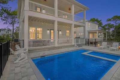 a house with a swimming pool in front of a house at Emerald Isle in Santa Rosa Beach