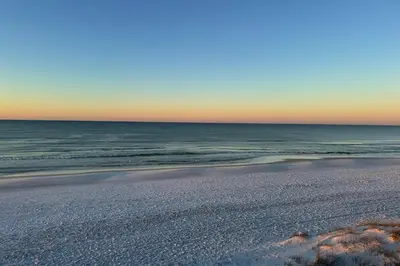 an empty beach with the ocean in the background at Emerald Isle in Santa Rosa Beach