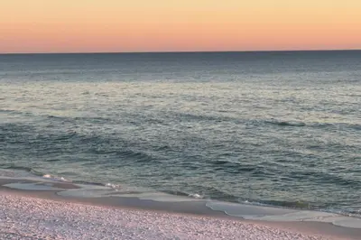 a view of the ocean from the beach at sunset at Emerald Isle in Santa Rosa Beach