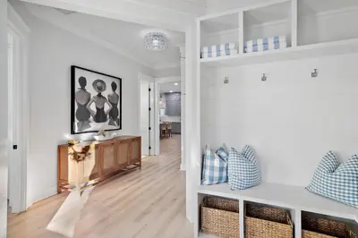 a living room with white walls and wood floors at Emerald Isle in Santa Rosa Beach