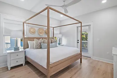 a white bedroom with a canopy bed and a window at Emerald Isle in Santa Rosa Beach