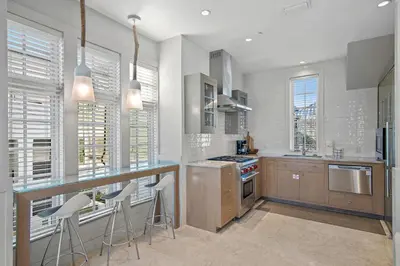 a kitchen with a counter and some chairs in it at 34 S Briland Lane Carriage House in Rosemary Beach
