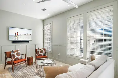 a living room with a white couch and a tv at 34 S Briland Lane Carriage House in Rosemary Beach